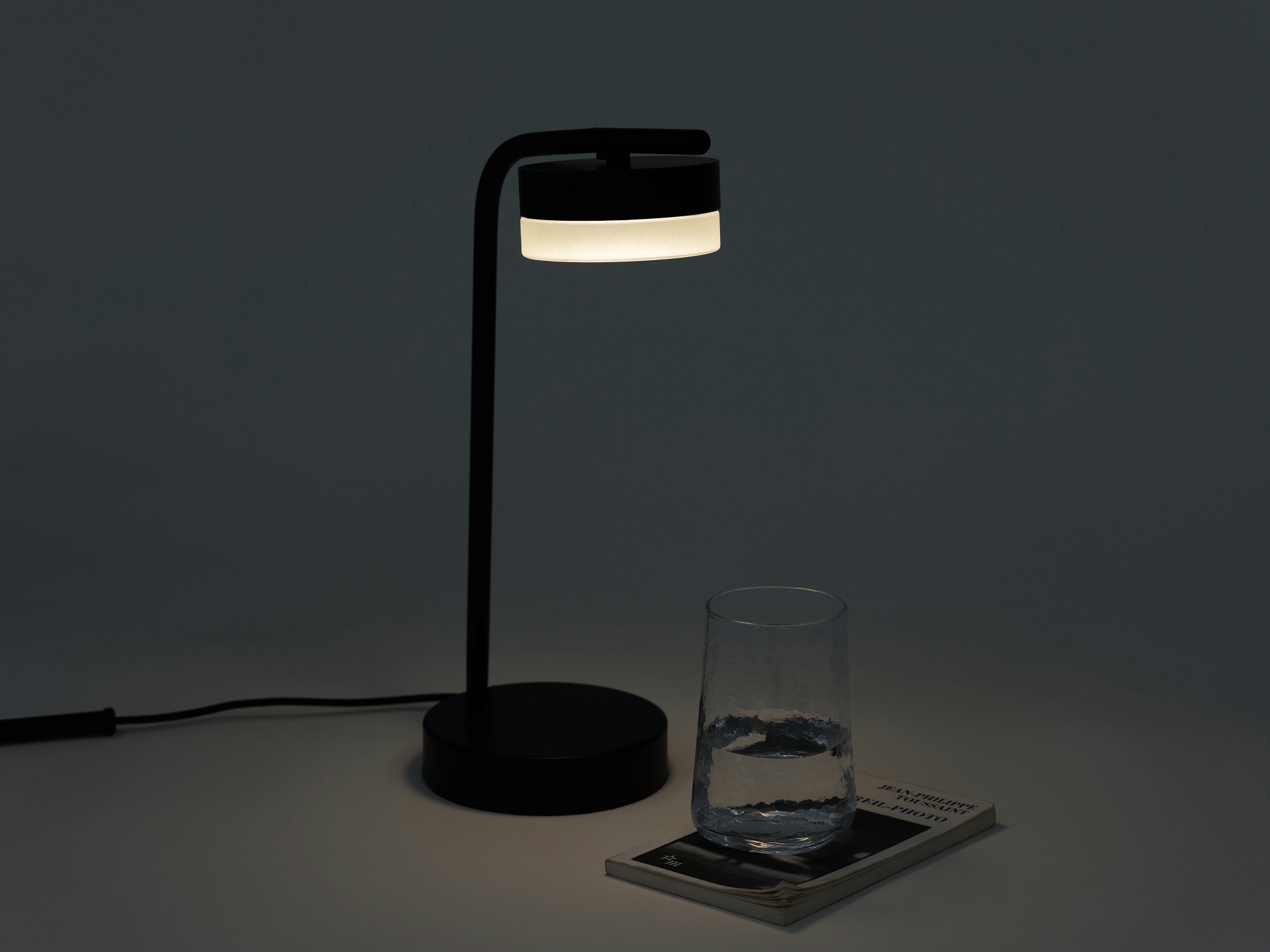 The Row bedside table lamp with a cup of water beneath it